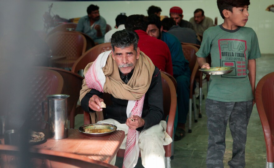 Men eat at a free cafeteria operated by the Pakistani charity Saylani. This cafeteria was recently opened to serve workers in the textile mills on the outskirts of the city of Faisalabad. It's one of 40 cafeterias the charity runs in Faislabad – nearly double what they operated two years ago, as the number of hungry grow.