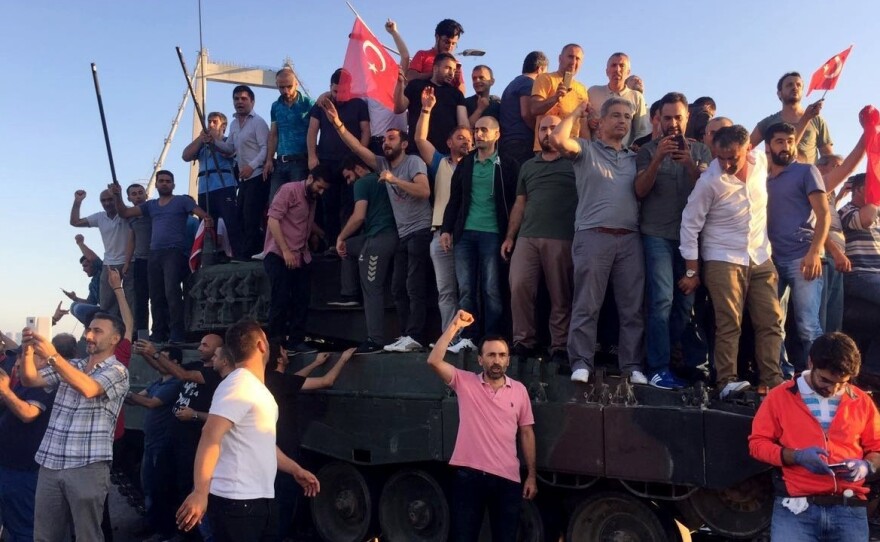 People climb on tanks after soldiers occupying Bosphorus Bridge surrendered in Istanbul, Turkey on Saturday.