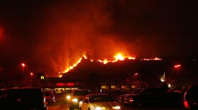 A fireline in the Cedar Fire makes its way down the hill near a Walmart October 27, 2003 near Lakeside in San Diego, California.