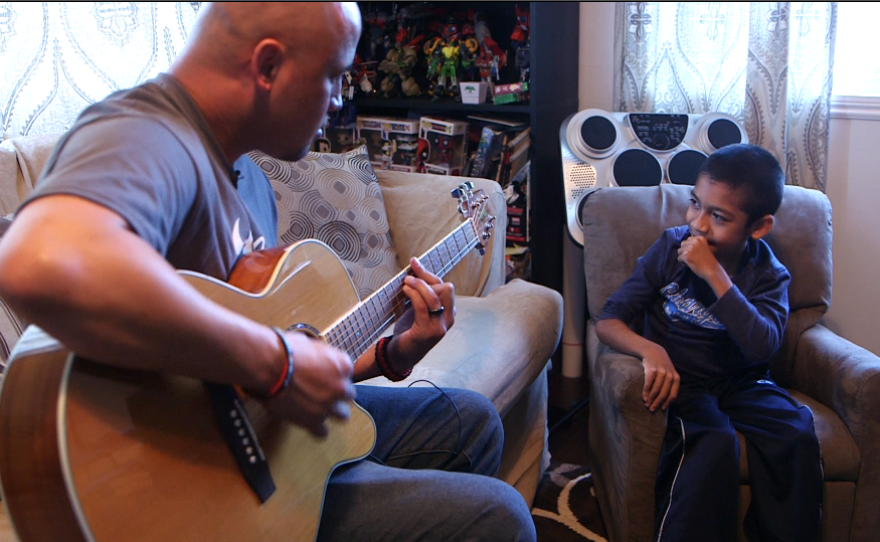 Damian Omler listens while his father Donnie plays guitar, Feb. 19, 2016.
