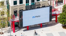 Workers walk past a display at Meta headquarters on Thursday, March 26, 2026, in Menlo Park, Calif.