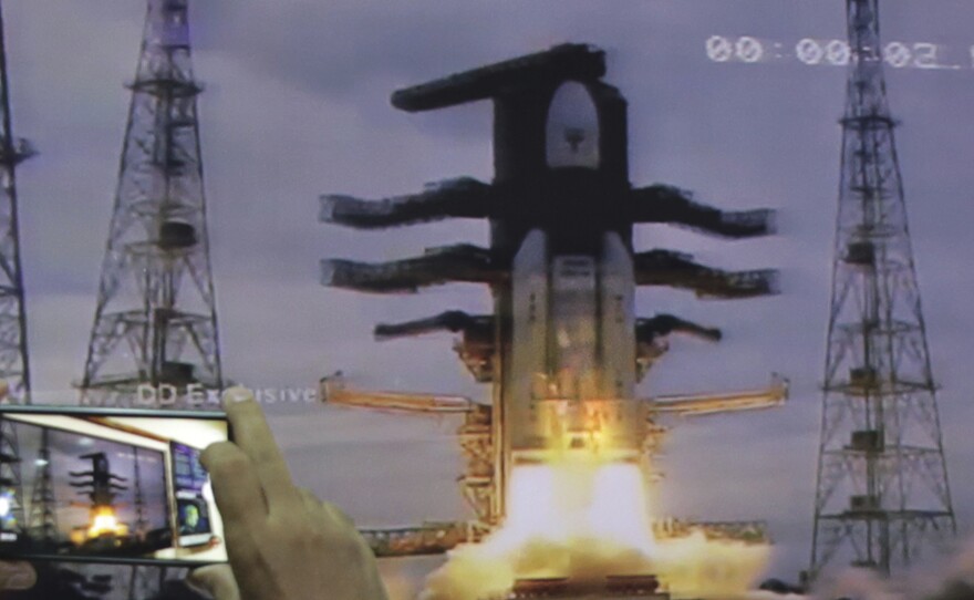 Through a webcast, a man at New Delhi's Nehru Planetarium takes pictures of the liftoff of the Indian Space Research Organization's unmanned spacecraft, launched Monday on a mission to the far side of the moon.