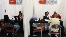 Wells Fargo employees help homeowners go over paperwork during a free workshop for customers who are facing mortgage payment challenges in Oakland, Calif.