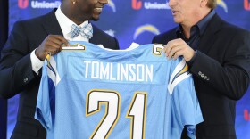Former San Diego Chargers running back LaDainian Tomlinson, left, and Chargers president Dean Spanos hold up Tomlinson's #21 jersey at a news conference held at the San Diego Chargers facility, June 18, 2012 in San Diego. 