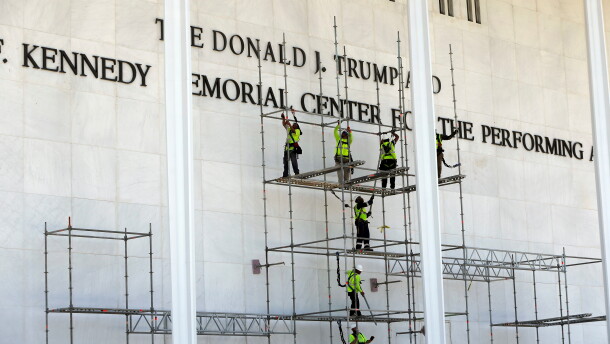 Workers construct scaffolding below the John F. Kennedy Center for the Performing Arts sign on Friday in Washington.