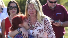 Parents wait for news after a reports of a shooting at Marjory Stoneman Douglas High School in Parkland, Fla., on Wednesday, Feb. 14, 2018. 
