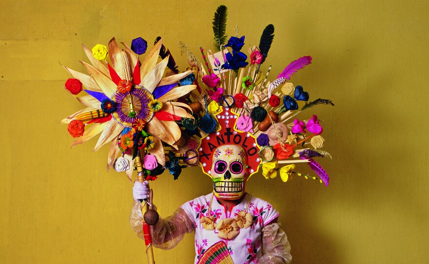 This costume, with corn husks and feathers and paper flowers, is worn by a member of a dance group that gathers in cemeteries and other places to mark Day of the Dead festivities (called Xantolo, the word written above the mask). The idea of combining a skeletal mask with European fashion was devised by the Mexican artist Jose Guadalupe Posada, who lived in the 19th and early 20th centuries.