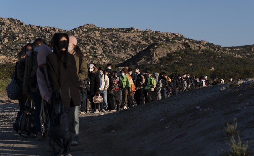 Chinese migrants wait to be processed after crossing the border with Mexico Wednesday, May 8, 2024, near Jacumba Hot Springs, Calif.