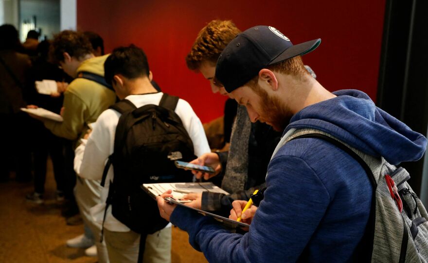 A young man fills out an application to cast his ballot at the Ann Arbor clerk's satellite office on the University of Michigan campus.