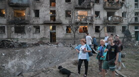 People look at the site of a Russian missile strike that hit a residential building in Kyiv, Ukraine, Thursday, July 2, 2026.