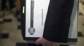 House Energy and Commerce Committee Chairman Rep. Greg Walden, R-Ore., one of the stewards of the Republican health care legislation, carries a binder labeled "Essential Health Benefits" as he leaves the Capitol Hill office of House Speaker Paul Ryan, March 24, 2017. 