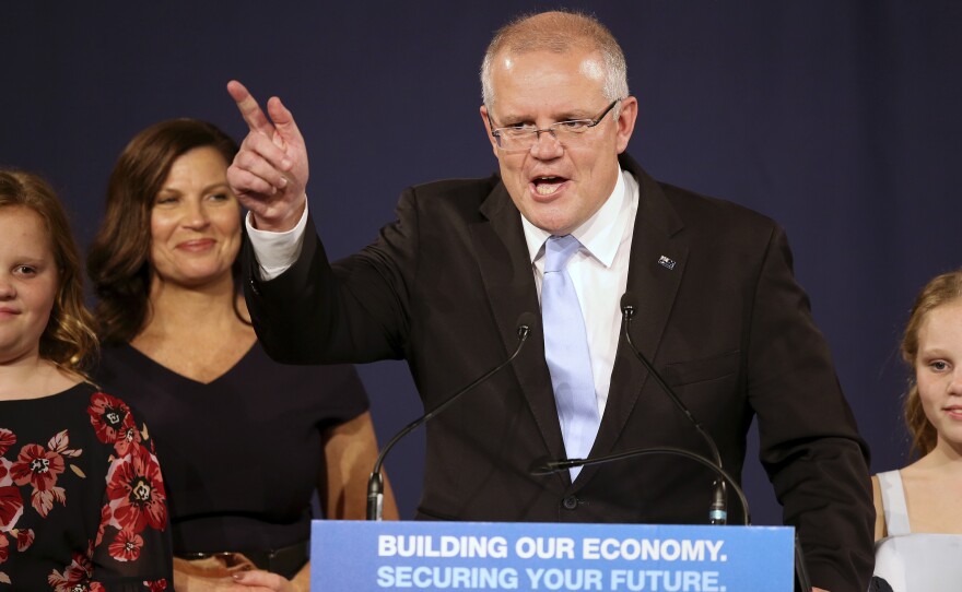 Australian Prime Minister Scott Morrison speaks to party supporters flanked by his wife and daughters. Morrison's conservative coalition won a surprise victory in the country's general election.