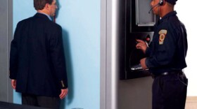 Employees at American Science and Engineering demonstrate how their full-body scanner is used.
