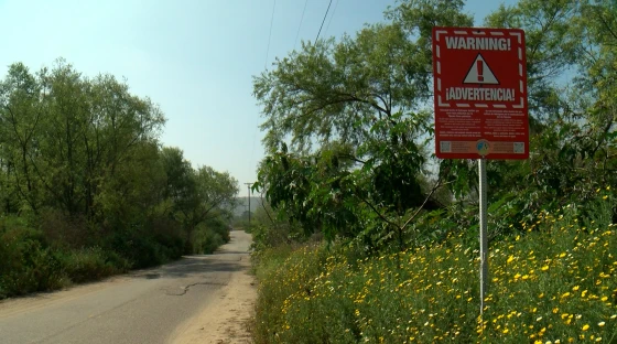 A sign along Saturn Boulevard in the Tijuana River Valley, known as a hot spot for airborne sewage pollution, warns of exposure to hydrogen sulfide in the area. May 28, 2026.