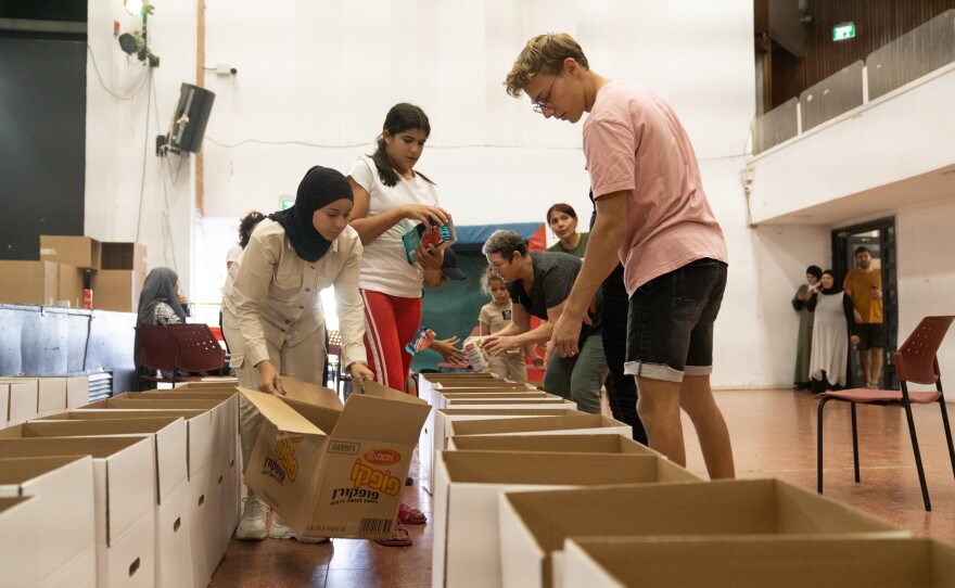 Volunteers help pack boxes of food donations at the community center in Lod.