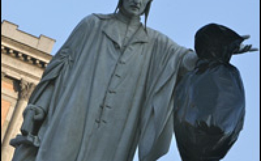 A trash bag hangs from the statue of Dante in Naples.