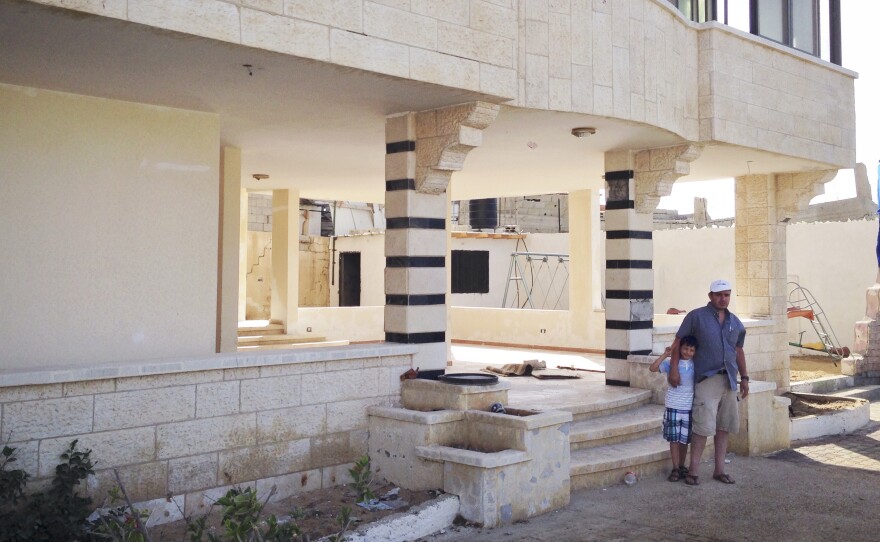 Ihab al-Aloul with his son Abdel Rahman outside the family's weekend house near the beach in Gaza.