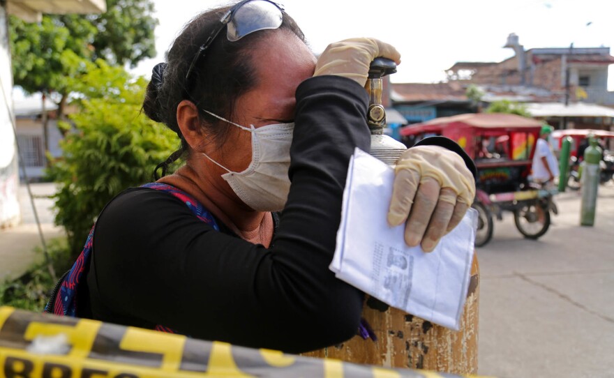 A relative of a COVID-19 patient waits to try to refill a medical oxygen tank in Iquitos in mid-May of 2020. The main oxygen plant in the city broke down days earlier leading to a surge in COVID deaths.