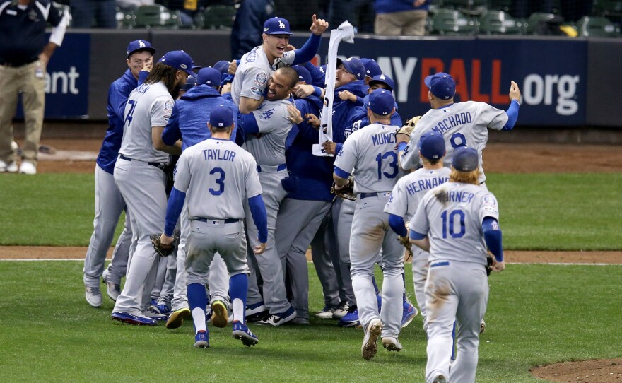 The Los Angeles Dodgers celebrate after defeating the Milwaukee Brewers in Game 7 to win the National League Championship Series at Miller Park on Saturday, in Milwaukee.