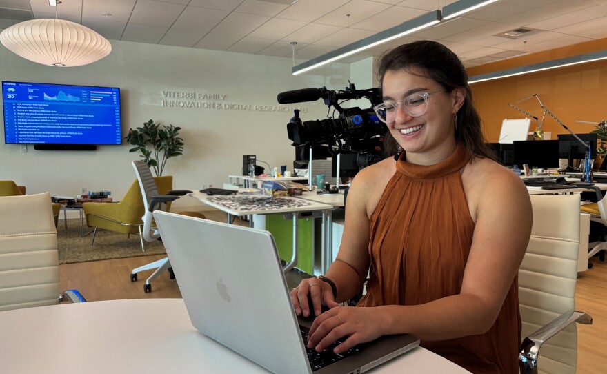 Cybersecurity researcher Ariana Miriam, sitting at her laptop, co-wrote a study on cybersecurity training.