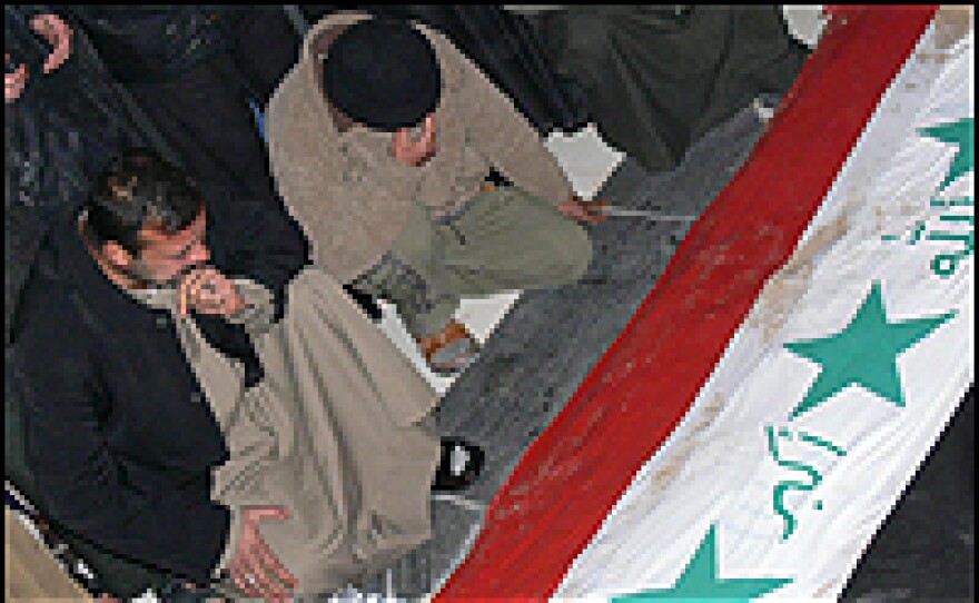 Iraqis grieve at the grave of ousted Iraqi dictator Saddam Hussein.