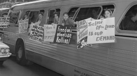 Freedom Riders hang posters from a bus. From May until November 1961, more than 400 black and white Americans risked their lives — and many endured savage beatings and imprisonment — for simply traveling together on buses and trains as they journeyed through the Deep South.