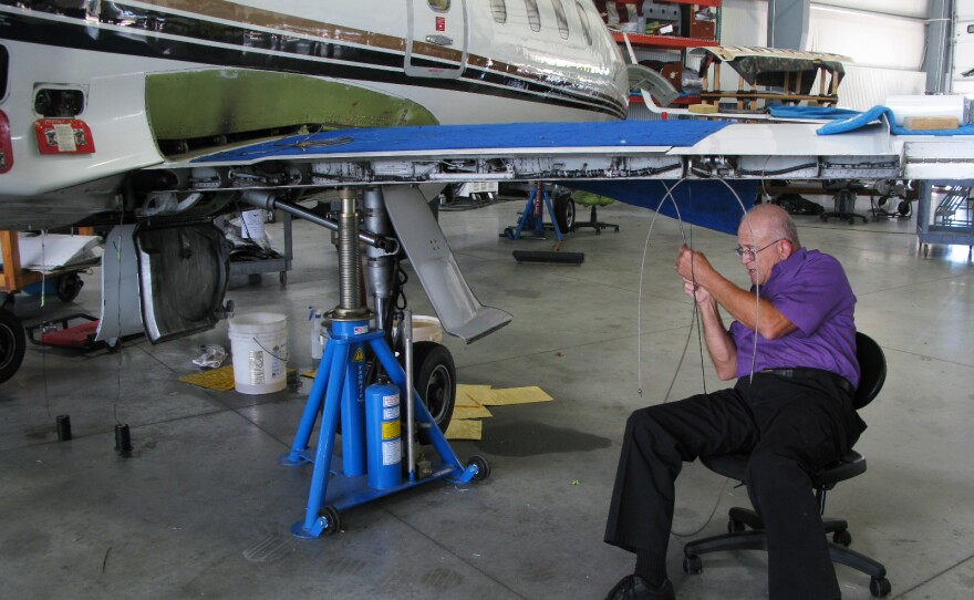 Mike Catherwood works on a Lear jet in a hangar in Springfield. The retired Air Force mechanic says his company, Spectra Jet, has so much work it needs more space.