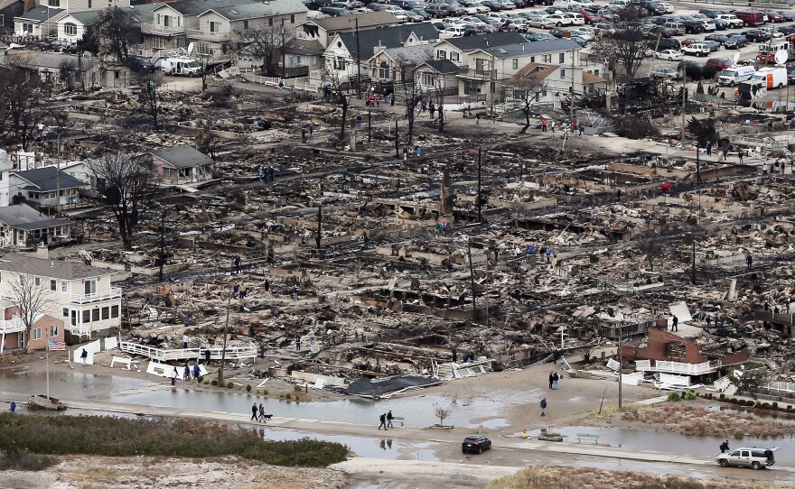 People walk near the remains of burned homes after Hurricane Sandy in the Breezy Point neighborhood of the Queens borough of New York City on Oct. 31, 2012. Over 50 homes were reportedly destroyed in a fire during the storm.