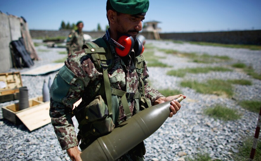 A soldier carries a shell to a Soviet-era artillery gun. Afghan officers say the Taliban not only cross the border, they hide in the villages, dropping their weapons and picking up a shovel when the soldiers appear.