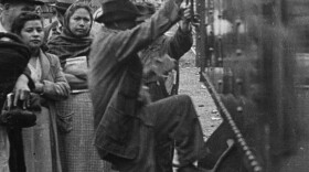Historical photo of a Mexican man boarding a train to look for temporary work in the United States as part of the Bracero Program. 