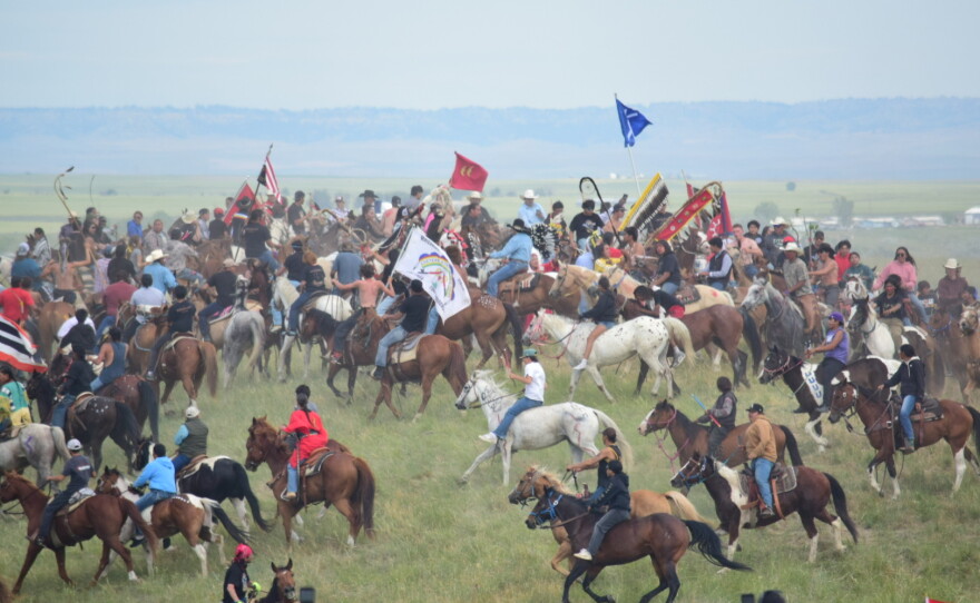 Horse mounted riders circle atop a hill at the Battle of Little Bighorn National Monument, near Last Stand Hill, on June 25.