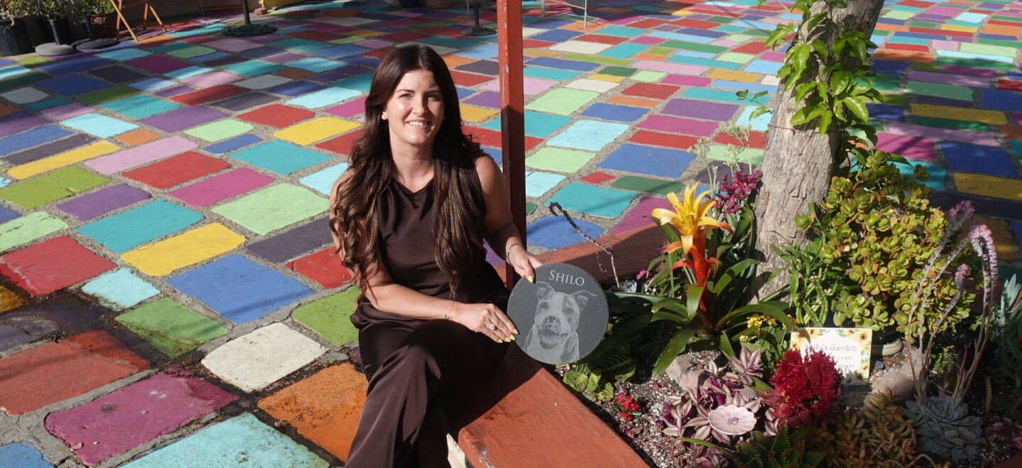 Amanda Moschella sits beside the garden she planted at Spanish Village Art Center in honor of her late dog, Shilo, on Sept. 14, 2026.