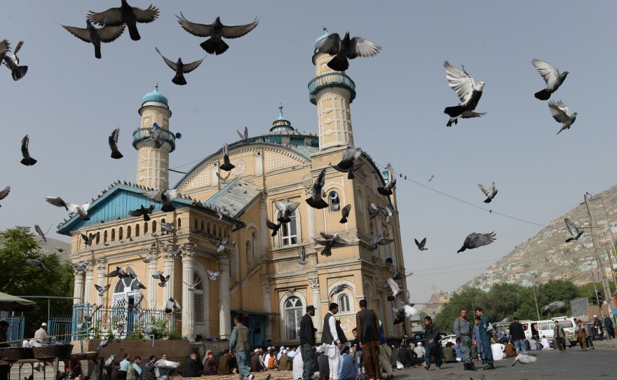 Pigeons fly into the air as Muslims offer prayers at the start of the Eid al-Fitr holiday, which marks the end of Ramadan, at the Shah-e Do Shamshira Mosque in Kabul on Friday. This Eid, Afghans welcomed the start of the Taliban's first ceasefire since the 2001 U.S. invasion