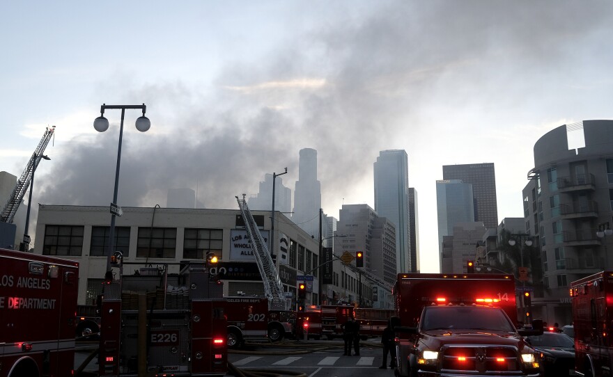 Smoke rises from the scene of a fire and explosion in Los Angeles on Saturday that injured 11 firefighters.