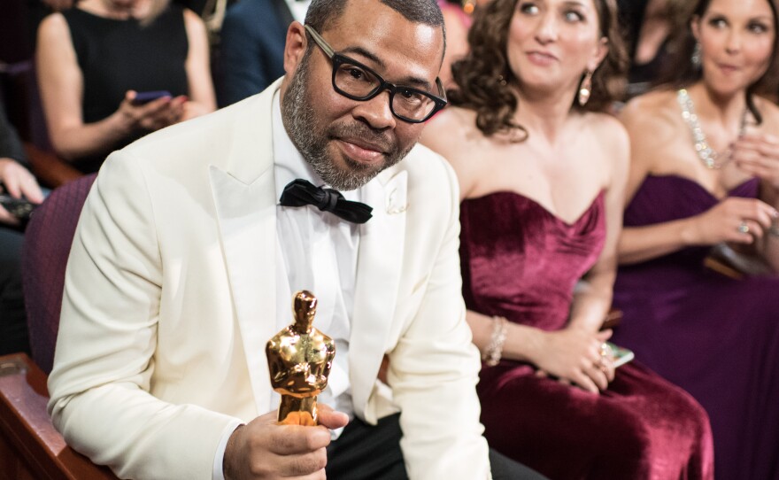 Filmmaker Jordan Peele takes his seat in the audience after winning his Oscar for best original screenplay, March 4, 2018.
