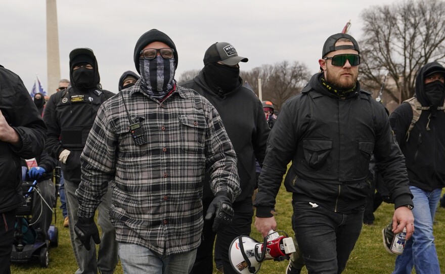 Proud Boy members Joseph Biggs (left) and Ethan Nordean, carrying a  megaphone, walk toward the U.S. Capitol on Jan. 6. They were among four people indicted for conspiring to attack the Capitol.
