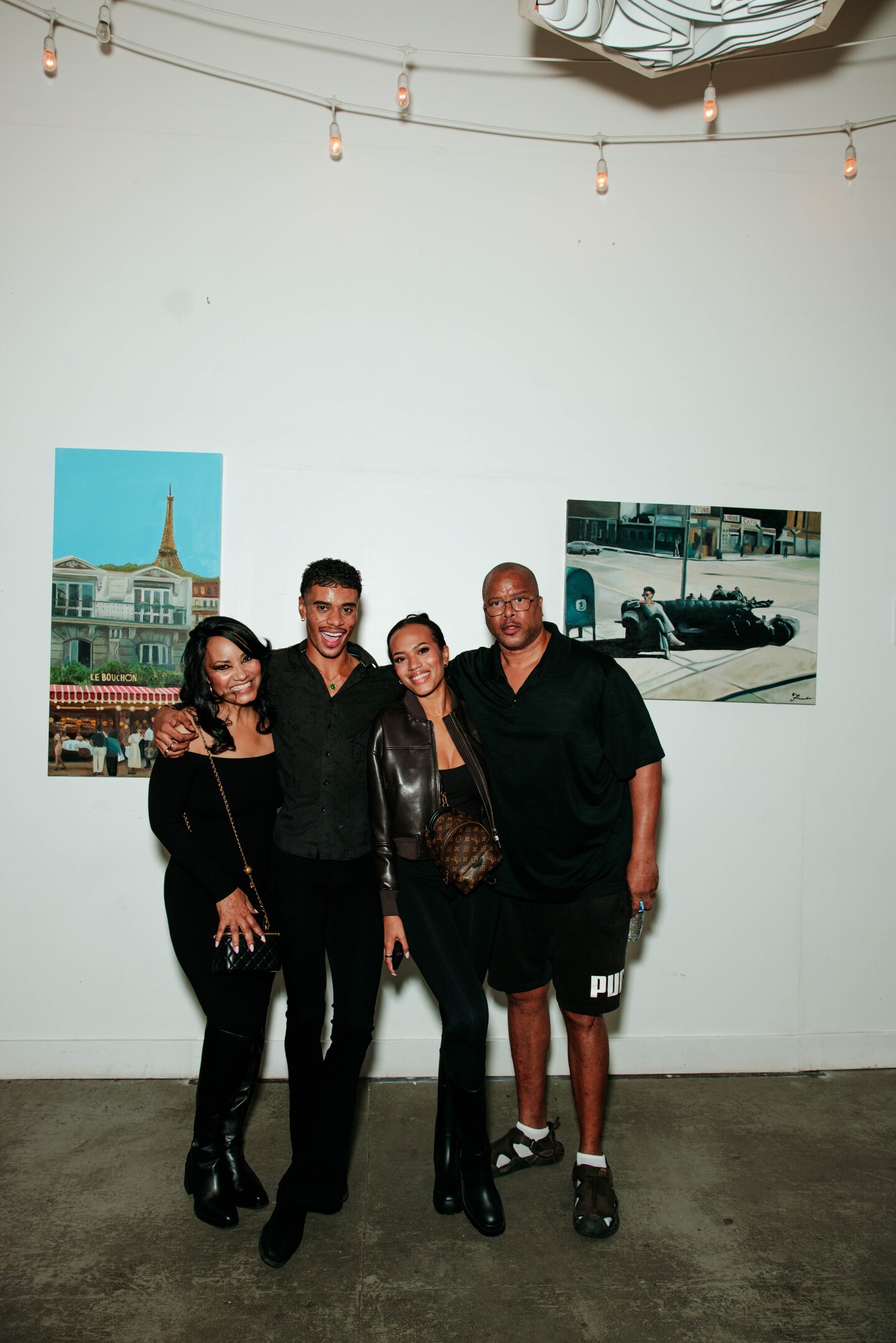Fredo poses in front of his art with his family in San Diego Made Factory for his first solo art show on Sept. 28, 2025