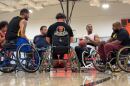 A group of people talk on the court while playing wheelchair basketball in City Heights, Oct. 1, 2025.