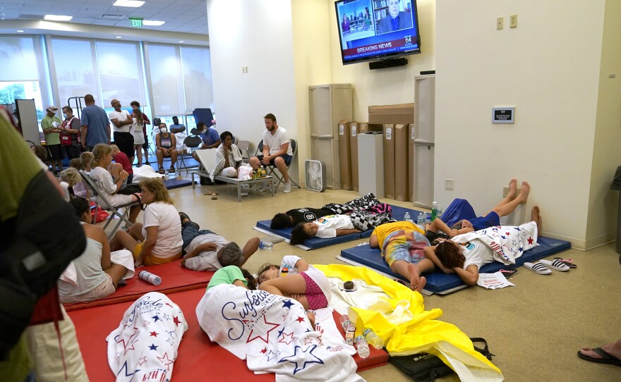 People lie on cots as they wait for news at the family reunification center on Thursday.