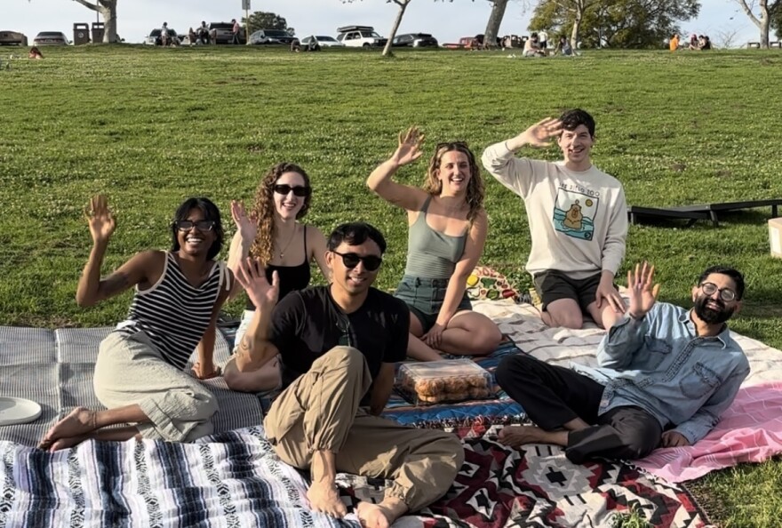 A group of friends wave in Kate Sessions Park, March 13, 2026.
