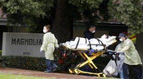 A patient is evacuated from the Magnolia Rehabilitation and Nursing Center in Riverside, Calif., Wednesday, April 8, 2020.