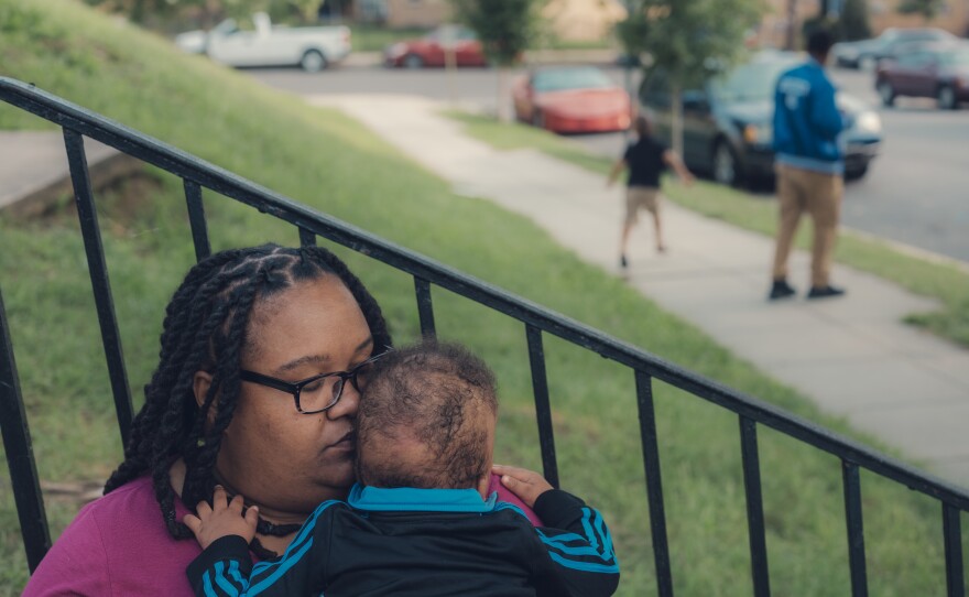 Patricia Stamper holds her younger son, 1, at their home.