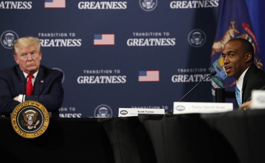 President Trump listens as Scott Turner, executive director of the White House Opportunity and Revitalization Council, speaks during a meeting with African American leaders in Michigan on Thursday.