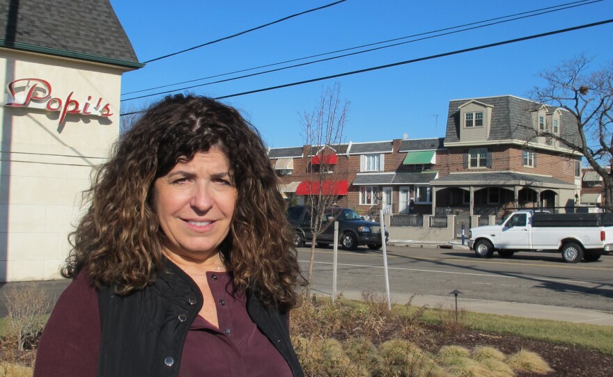 Gina Rucci stands by a new rain garden built in the parking lot of her restaurant in South Philadelphia. The improvements have cut her water runoff bill by 60 percent.