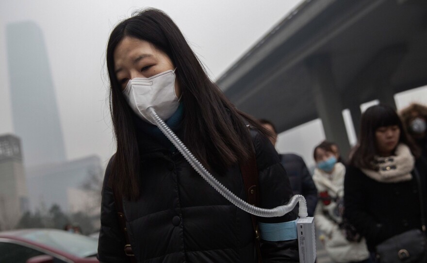A woman wears a mask and filter as she walks to work during heavy pollution in Beijing, China.