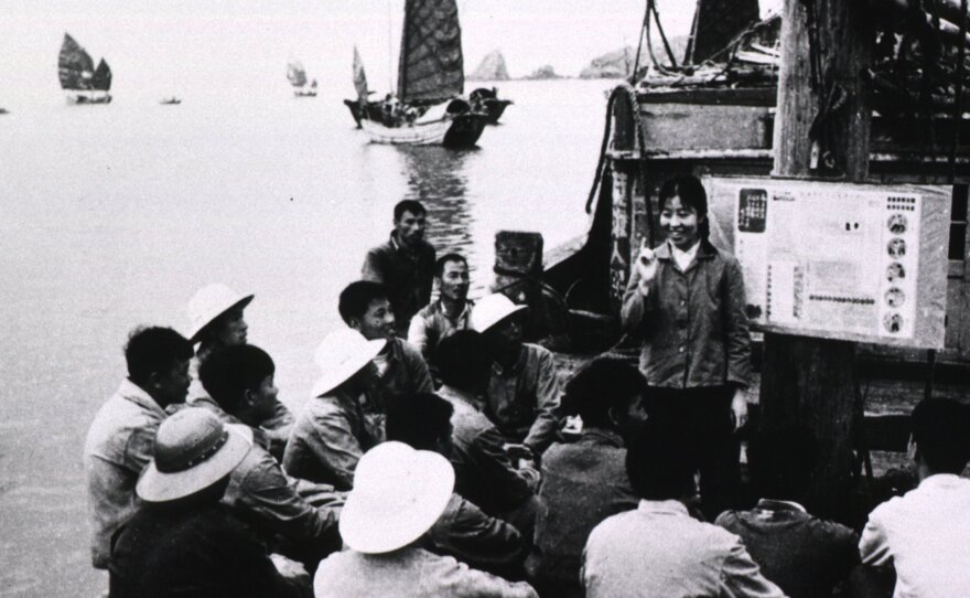 A community worker teaches fishermen about staying healthy.