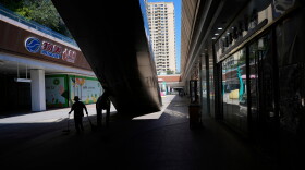 A worker collects trash in a partially shuttered Evergrande commercial complex, on the day Hong Kong Stock Exchange delisted the Chinese property developer China Evergrande, in Beijing, China, Aug. 25, 2025.
