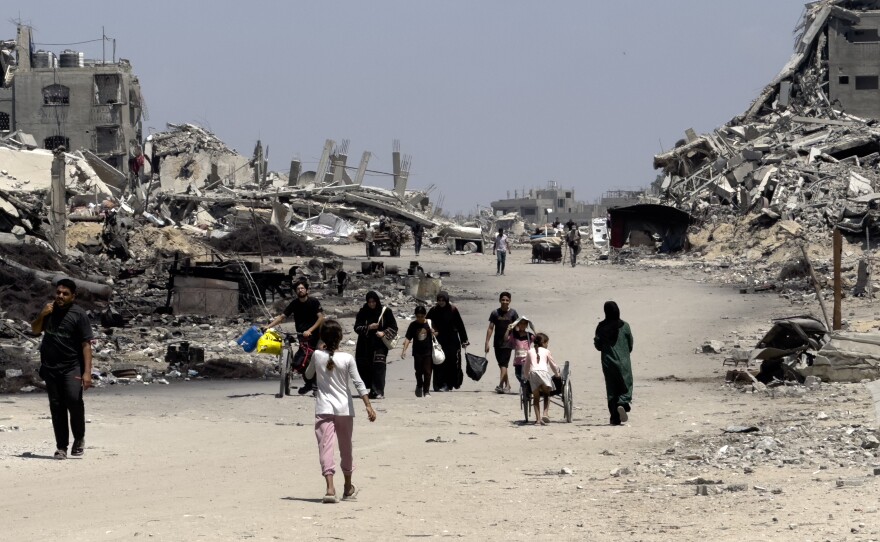 Families leave northern neighborhoods of Gaza City with the few items they can carry on Aug. 26, after Israeli tanks and airstrikes force them out.