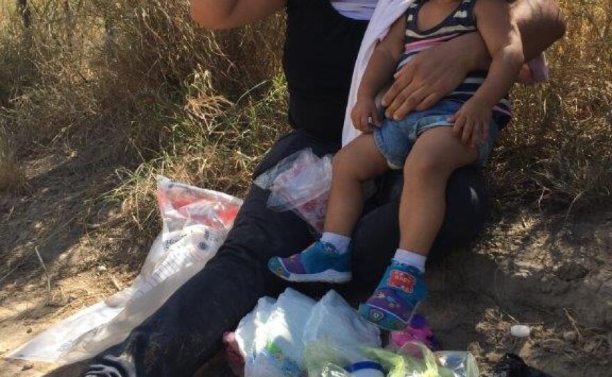 An immigrant from El Salvador and her 1-year-old daughter apprehended after crossing the Rio Grande near McAllen, Texas. She will ask for asylum.