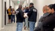 Several Immigration and Customs Enforcement (ICE) agents stand in the hallway of San Diego's immigration court, waiting to detain people as they exit their court hearings on Thursday May 22, 2025.